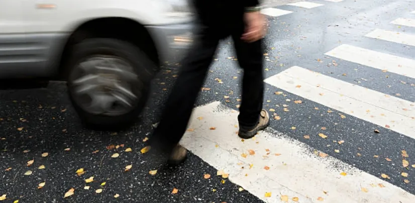 pedestrian crossing at the crossing walk as a car approaches